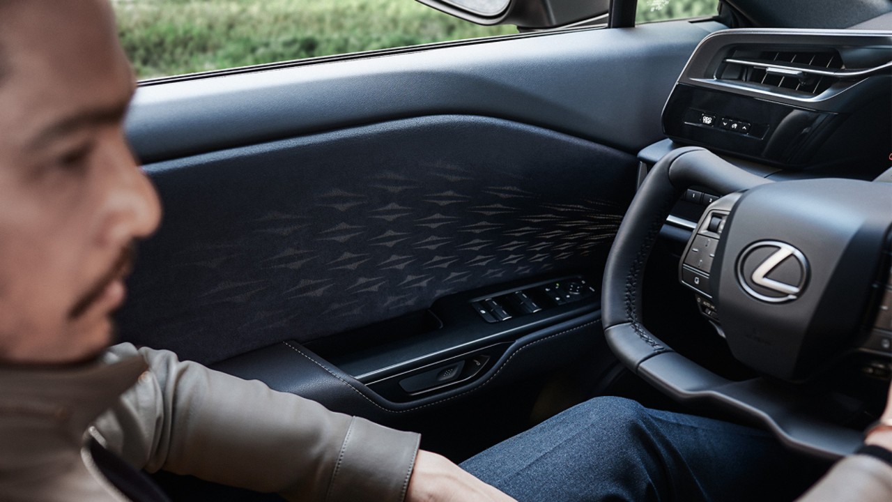 A man sat in the drivers seat of a Lexus RZ 450e